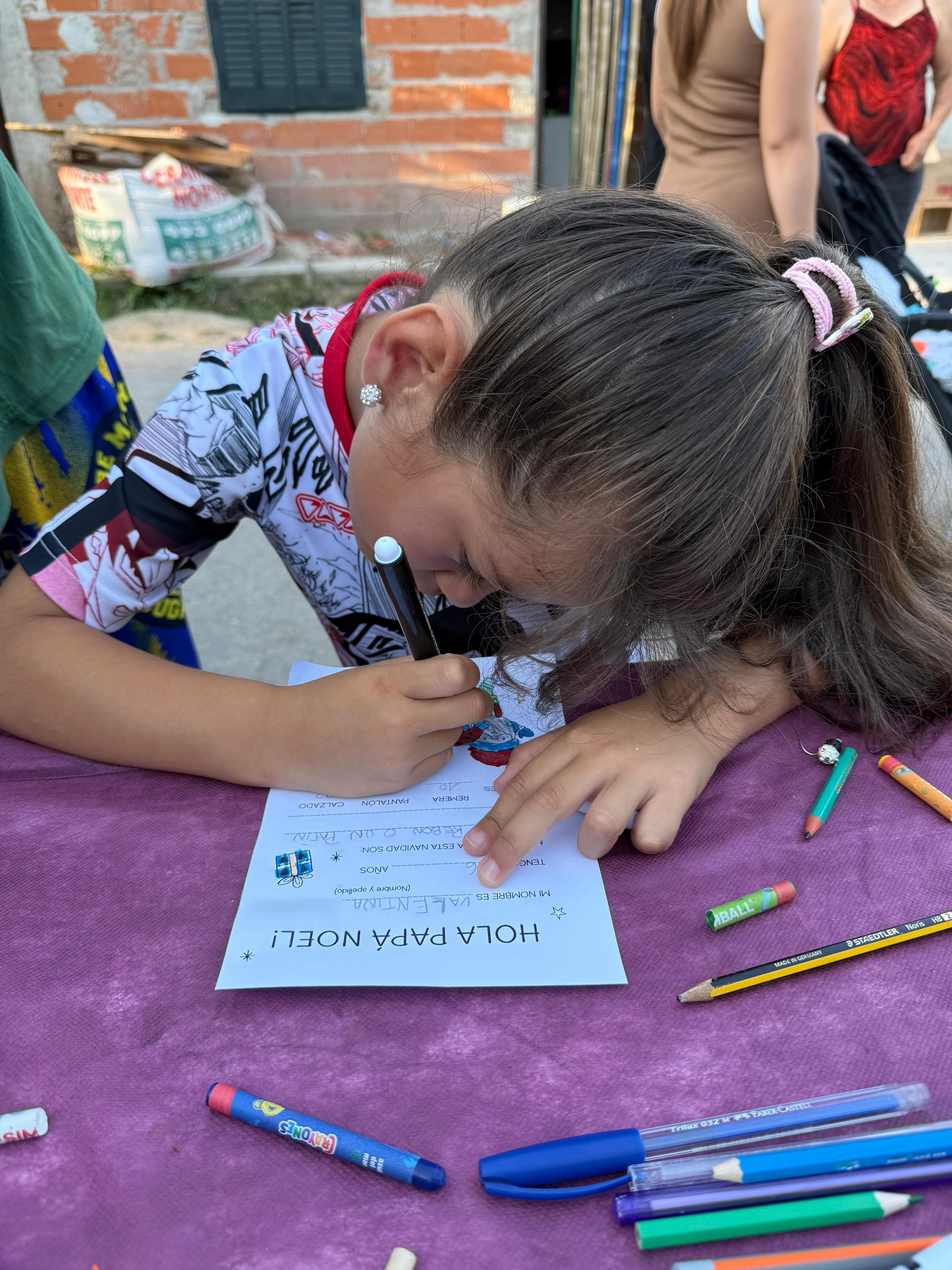 Una nena escribiendo su carta a Papá Noel